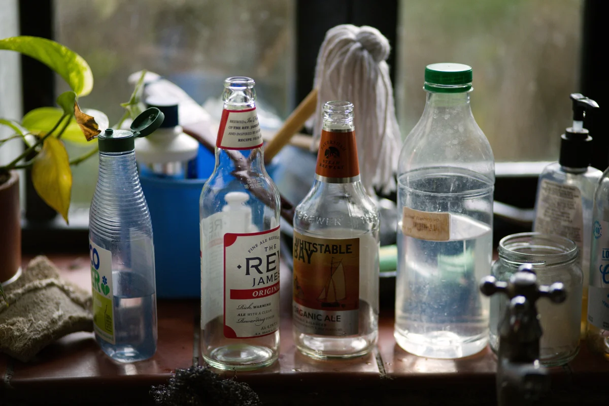 cleaning supplies gathered kitchen counter - Cozyner
