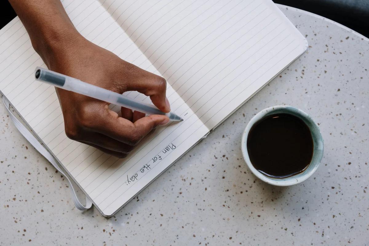 person writing planner journal morning - Cozyner