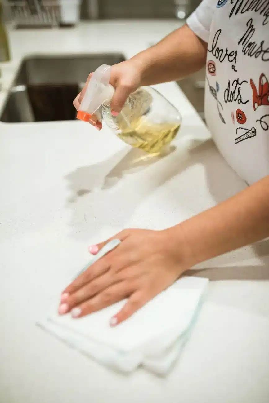 Person wiping a kitchen counter as part of daily cleaning tasks