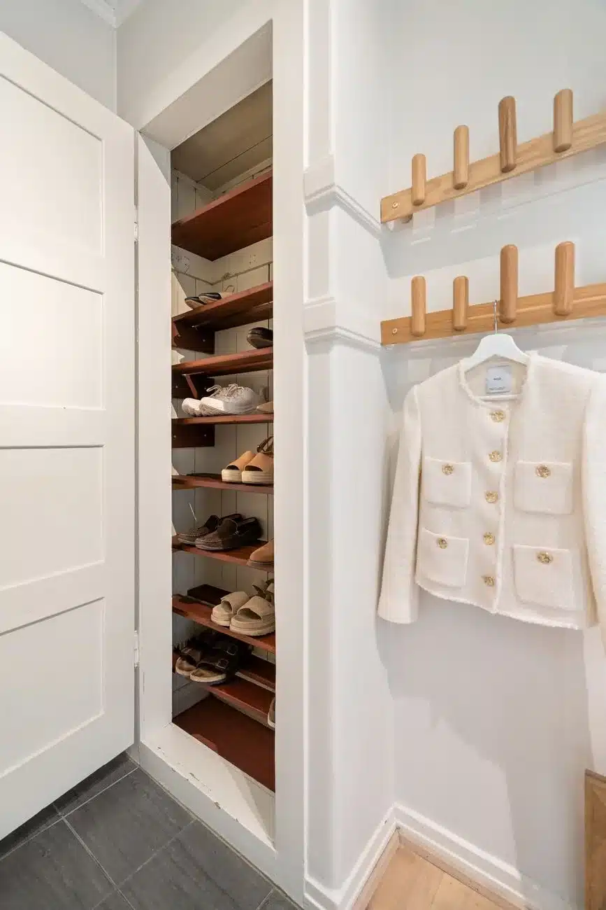 Small apartment closet with organized shoe storage and coat rack